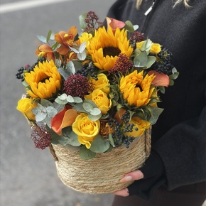 Композиция в сумке "Тональность" из подсолнухов, калл, ягод вибирнума, лимонных роз, скиммии и орхидеи в Раменском